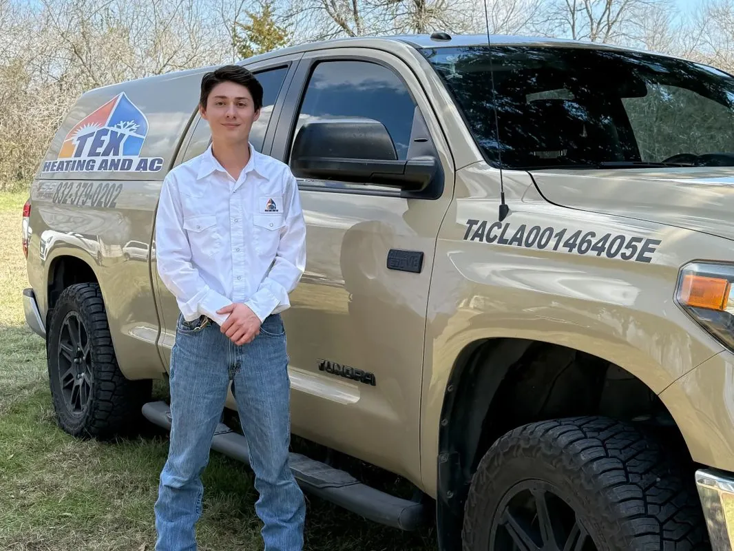 TEX Heating and AC technician standing next to the licensed company service truck