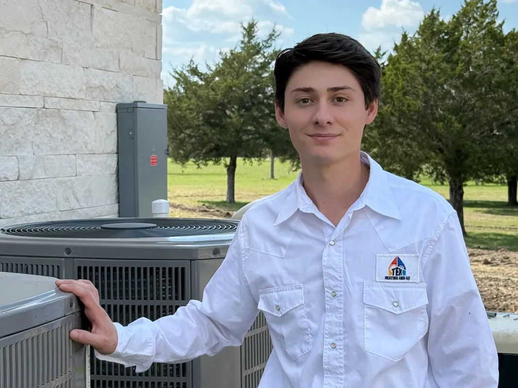 TEX Heating and AC technician with a newly serviced outdoor AC unit at a Houston-area home